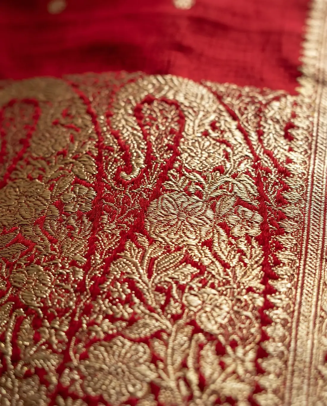 Close-up of a gold zari paisley pallu on red silk