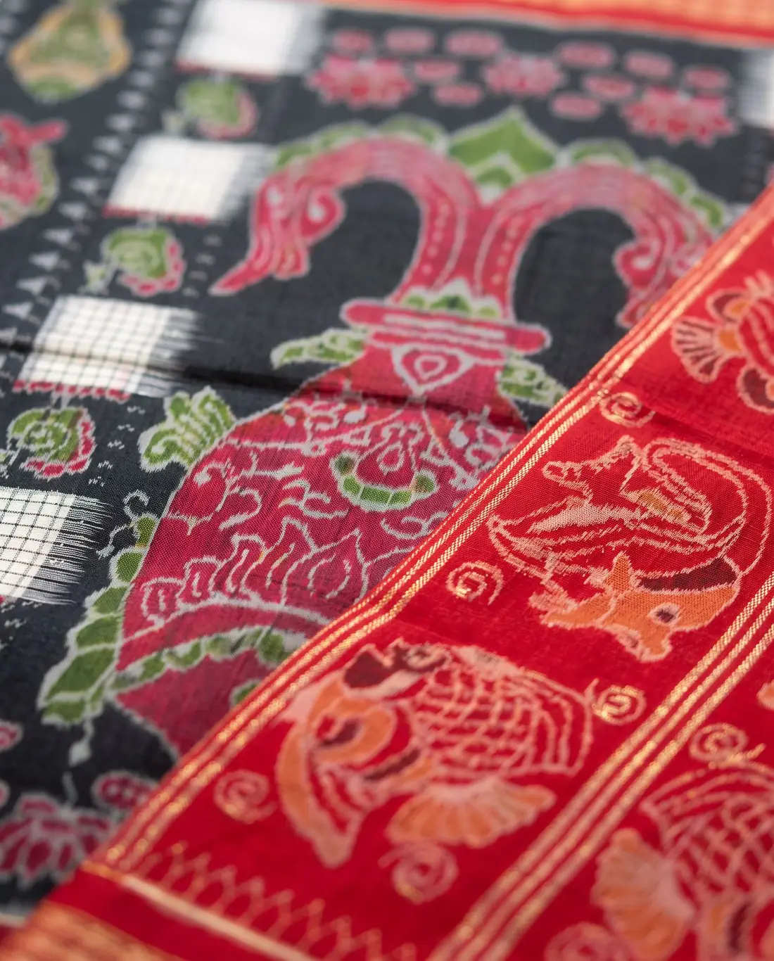 Close-up of red and black ikat with fish and temple motifs
