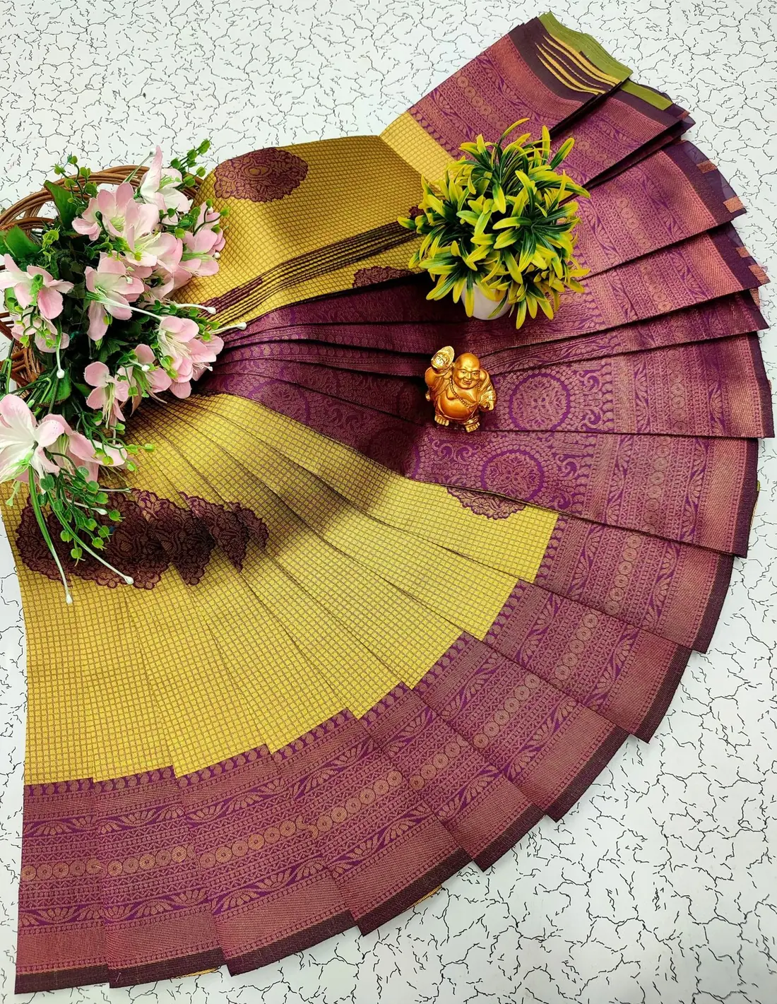 Seller's phone photo: mustard silk saree with small zari checks and a purple-maroon zari border, pleats fanned out